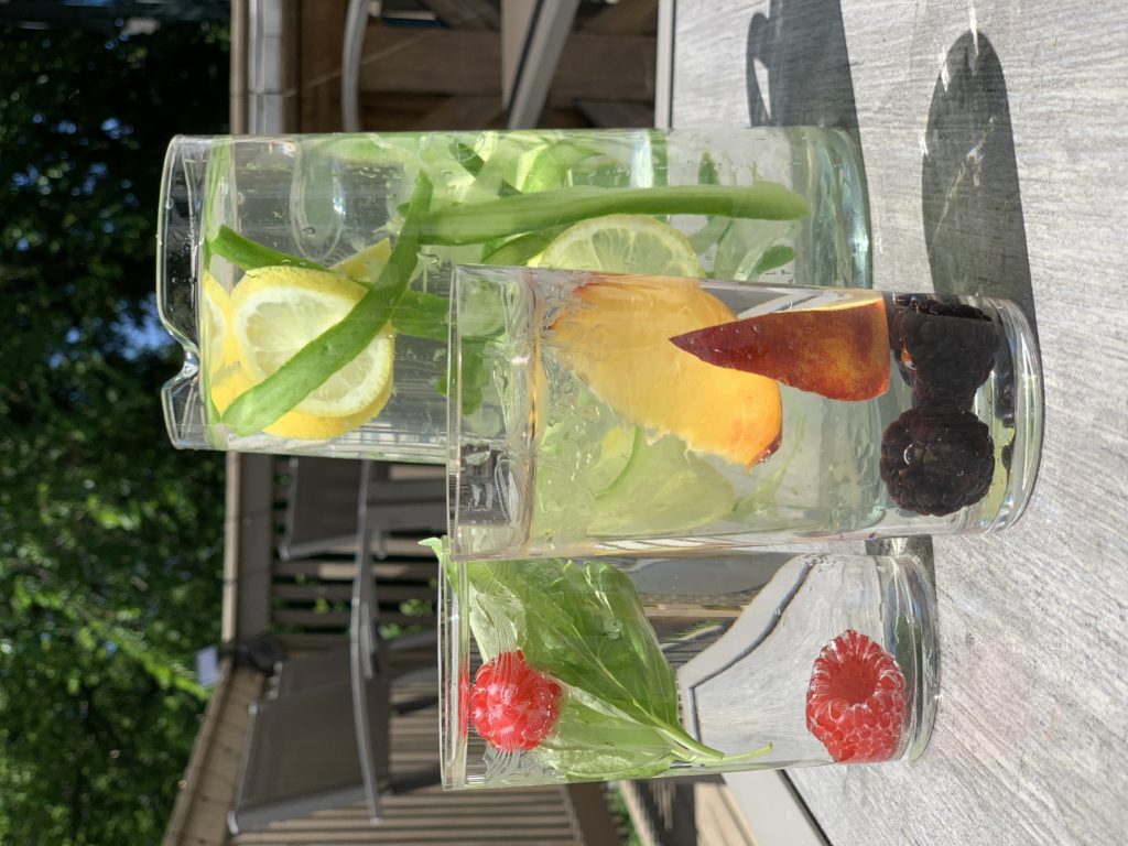 Ice cold glass of fruit infused water and homemade fruit ice pops